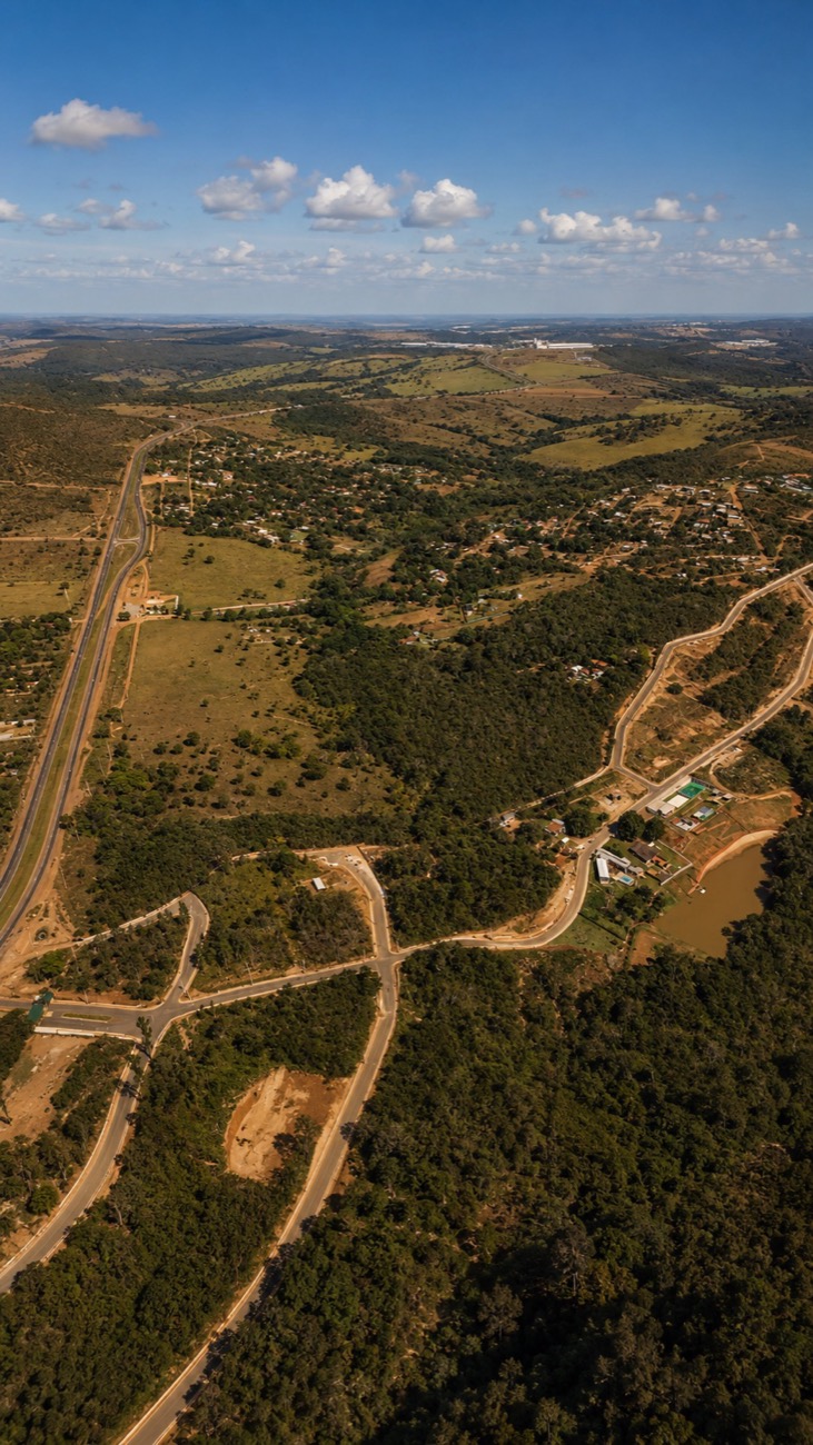 Vista aérea de um condomínio de lotes no cerrado, com ruas asfaltadas e um lago